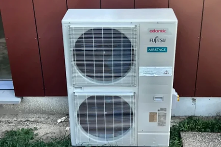 Groupe extérieur de climatisation Atlantic Fujitsu Airstage installé contre la façade d'une école maternelle à Saint-Laurent-Nouan (41).