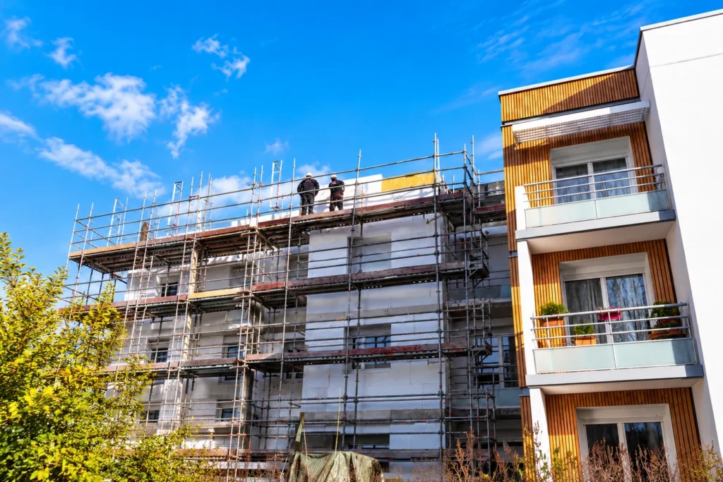 Travaux de rénovation énergétique d’un immeuble collectif avec pose d’isolation extérieure sur échafaudages.