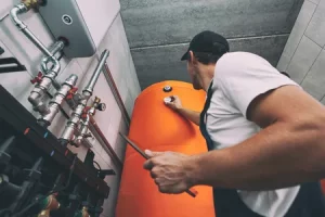 Professionnel intervenant sur un équipement de production d’eau chaude sanitaire dans un bâtiment tertiaire